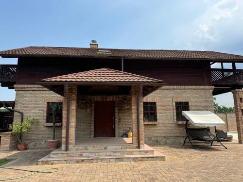 een bakstenen huis met een dak en een grill bij Julies Villas in Štúrovo