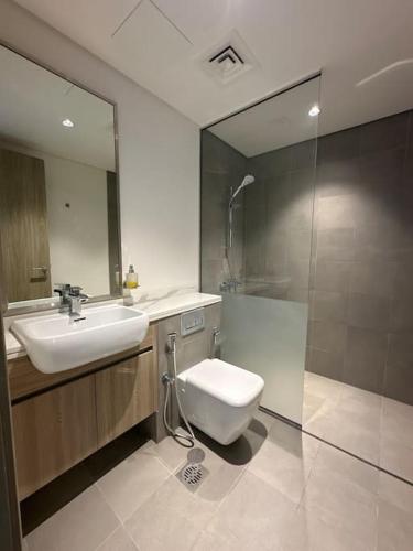 a bathroom with a toilet and a sink and a mirror at Ajmal Chalet in Al Ḩamrīyah