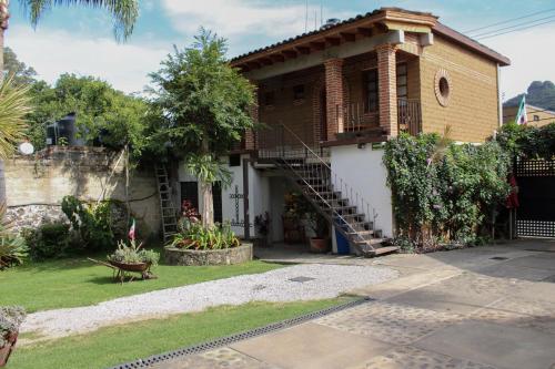 a house with a spiral staircase in front of it at Posada Guayacán Tepoztlán in Tepoztlán