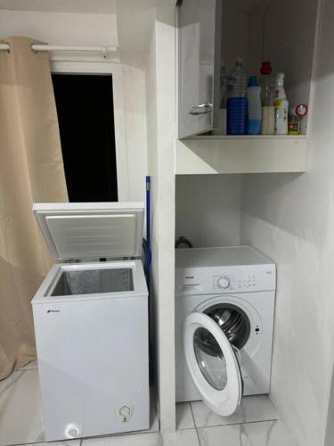 a laundry room with a washing machine and a washer at Plezi Location T2 Nature, Trois-Ilets in Les Trois-Îlets