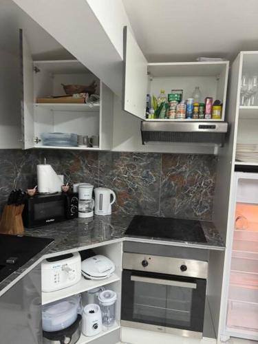 a kitchen with white cabinets and a stove at Plezi Location T2 Nature, Trois-Ilets in Les Trois-Îlets