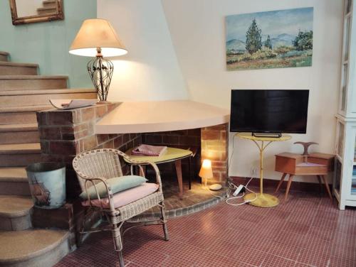 un salon avec une cheminée et une télévision dans l'établissement Maison Vintage - Clim - Wifi - Parking dans la rue, à Avignon