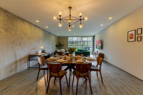 a dining room with a table and chairs at Capitalia Galileo Residences in Mexico City