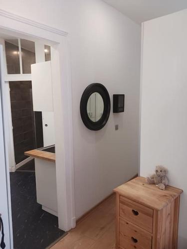 La salle de bains est pourvue d'un miroir et d'une table en bois. dans l'établissement Appartement à 50m des Thermes, à Aix-les-Bains