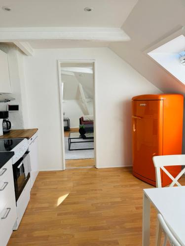 a kitchen with an orange cabinet in a room at Cozy 2-room Apartment in Aarhus