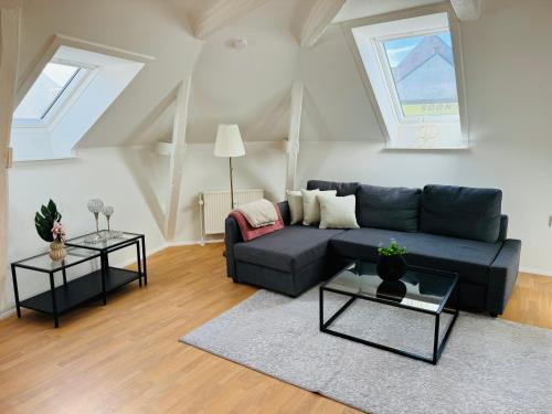 a living room with a blue couch and two tables at Cozy 2-room Apartment in Aarhus