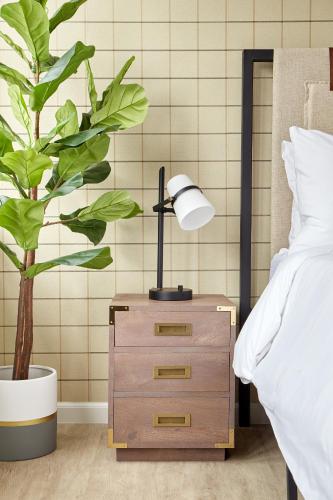 a nightstand with a lamp on it next to a plant at Kasa Cadillac Square Detroit in Detroit