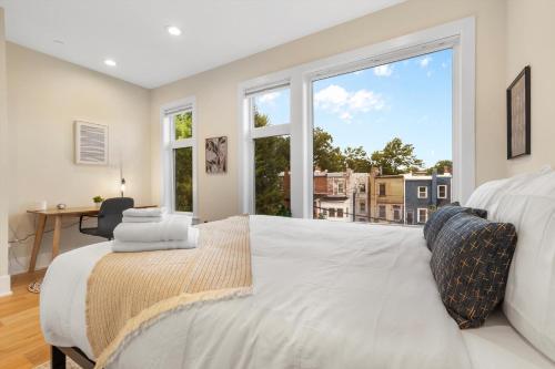 a bedroom with a large white bed with a large window at Central DC 5-BR Townhome - Walk to METRO-rail in Washington, D.C.