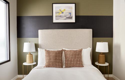a bedroom with a white bed with two lamps at Kasa Cadillac Square Detroit in Detroit