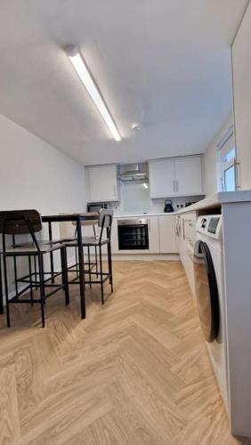 a kitchen with a table and chairs and a washer at Harbour View Belfast in Belfast
