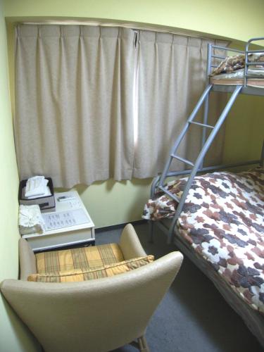 a room with a chair and a desk and a bunk bed at Nikko Park Lodge Tobu Station in Nikko