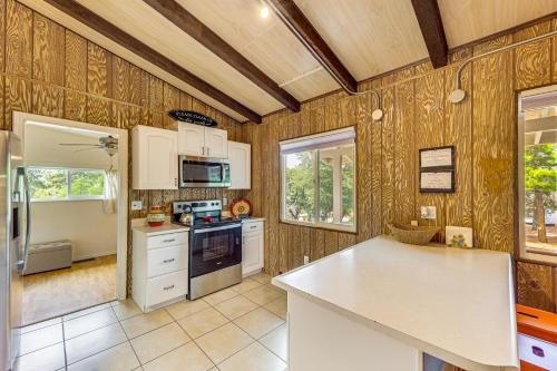 a kitchen with wooden walls and white appliances at 2 Mi to Dtwn Home with Deck and Grill in Payson in Payson