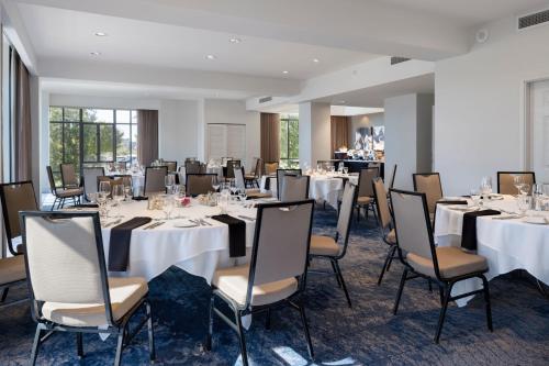 a banquet room with tables and chairs with white tablecloths at Delta Hotels by Marriott Victoria Ocean Pointe Resort in Victoria