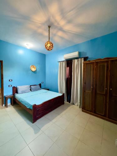a bedroom with a bed in a blue room at Lighthouse Residence in Dahab