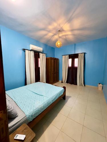 a bedroom with a bed and blue walls and a ceiling at Lighthouse Residence in Dahab
