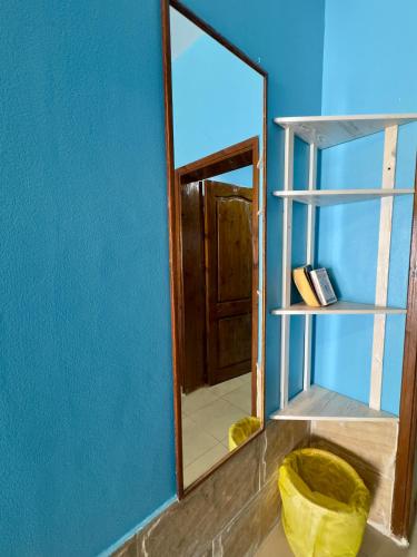 a mirror in a room with a blue wall at Lighthouse Residence in Dahab