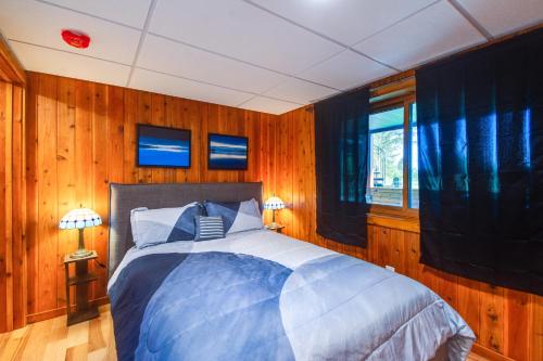a bedroom with a large bed with wooden walls at Washington Gem on 8 5 Acres Clamming Nearby! in Port Ludlow