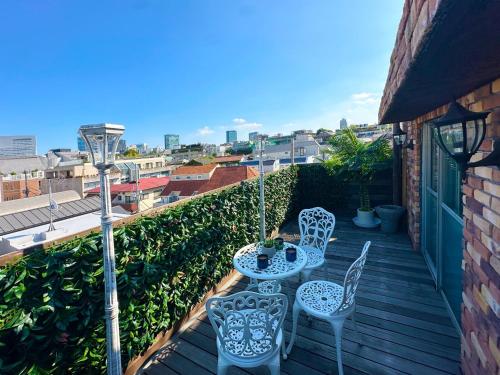 a patio with two chairs and a table on a balcony at Spacious 80sqm Apt near Shibuya Crossing, 8 min walk to Shibuya Station in Tokyo