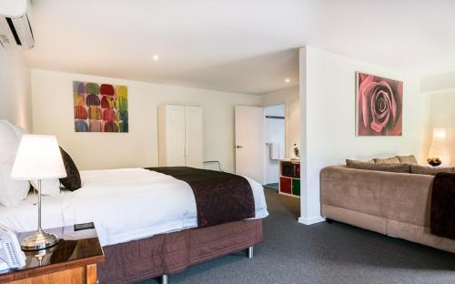 a hotel room with a bed and a couch at Balconies Dolphincove in Tura Beach