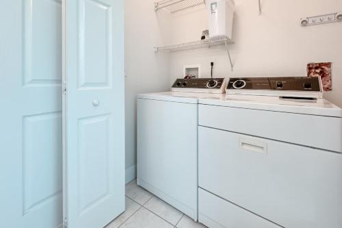 a kitchen with white cabinets and a stove at The Yellow House South at Herons Walk in Pensacola