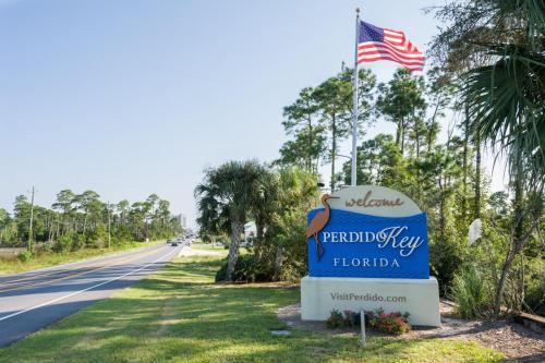 a sign in front of a road with an american flag at The Yellow House South at Herons Walk in Pensacola