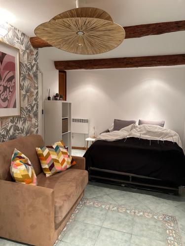 une chambre avec un lit et un canapé dans l'établissement Studio Brin Damour, à Sillans-la-Cascade