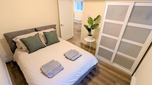 a bedroom with a bed with two towels on it at New 1 bedroom suite North Vancouver in Lynn Creek