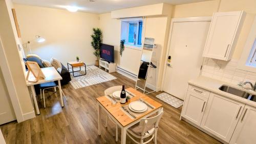 a kitchen and a living room with a table at New 1 bedroom suite North Vancouver in Lynn Creek