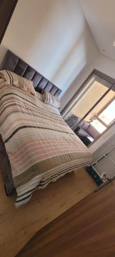 a bed in a room with a window at Appart à Malaga Beach Mansouria in Mansouria