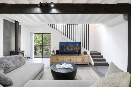 a living room with a couch and a table at Waterfront Stay, Pet Friendly 1 Night Stays! in St Georges Basin