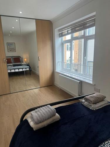 a bedroom with a mirror and a bed in a room at 2 bedroom, Parking, Hounslow St in London