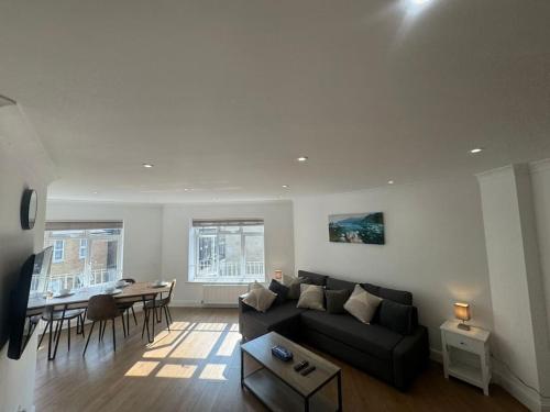 Una sala de estar con un sofá negro y una mesa. en 2 bedroom, Parking, Hounslow St, en Londres