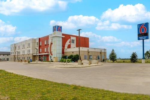a building with a fedex sign in a parking lot at Motel 6-Headingley, MB - Winnipeg West in Winnipeg