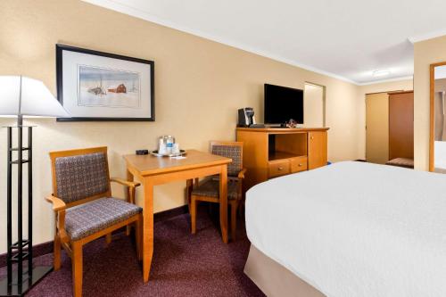 a hotel room with a bed and a table and chairs at Best Western Plus NorWester Hotel & Conference Centre in Thunder Bay