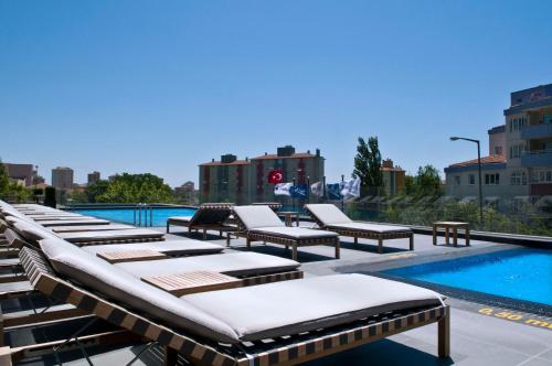a row of chaise lounge chairs next to a swimming pool at Radisson Blu Hotel Istanbul Asia in Istanbul