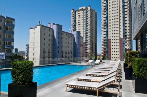 a pool with lounge chairs on top of a building at Radisson Blu Hotel Istanbul Asia in Istanbul
