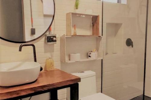 a bathroom with a sink and a toilet and a mirror at Apartamento Industrial tipo Loft in Circasia