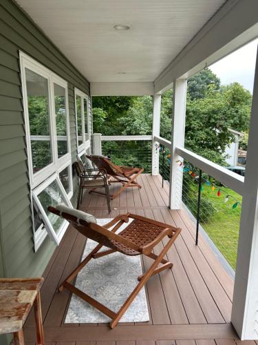 a porch with two chairs and a bench on it at Roberts Lake House Room #3 in Colchester