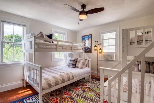 a bedroom with two bunk beds and a ceiling fan at Spacious 6BR close to Portsmouth beaches and UNH in Dover