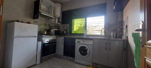a kitchen with a refrigerator and a washing machine at Appartement meublé in Ville Nouvelle