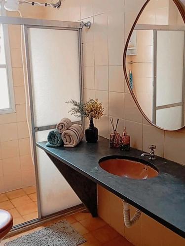 a bathroom with a sink and a mirror at AP Ventidor in Guarapari