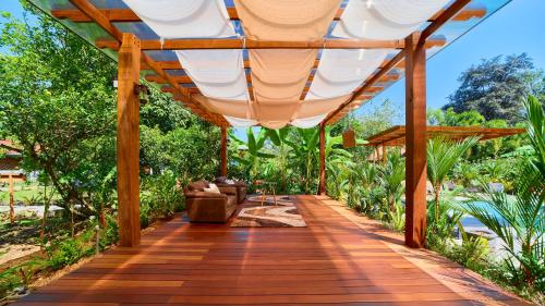 a wooden boardwalk leading to a house with a pergola at Casa Blossom - Beach Paradise Retreat, Fully Equipped, Holiday Home in Puerto Viejo