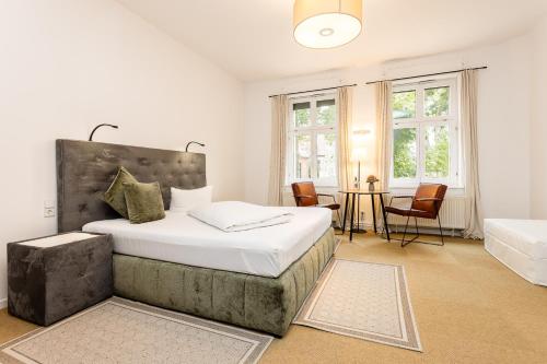 a bedroom with a large bed and a table at Hotel Zur Linde Dein Self Check In in Michendorf