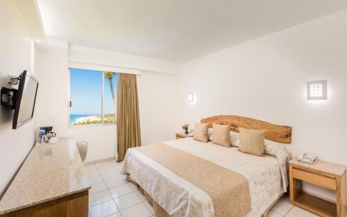 a bedroom with a bed with a view of the ocean at Posada Real Puerto Escondido in Puerto Escondido