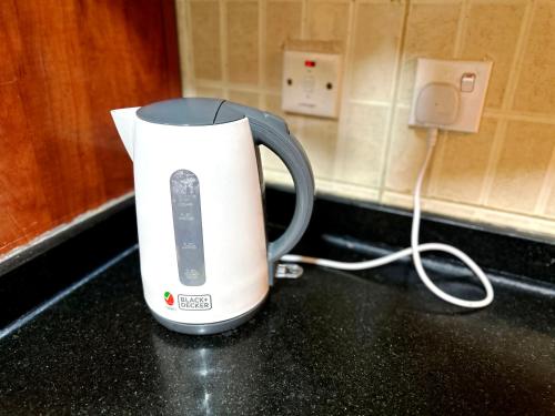 a coffee maker sitting on a counter next to an electrical outlet at Pathfinder Partition Room in Barsha Heights Tecom in Dubai