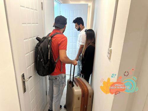 a group of people standing in a hallway with luggage at Pathfinder Partition Room in Barsha Heights Tecom in Dubai