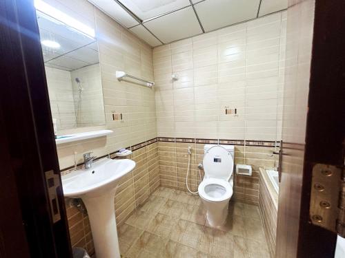 a bathroom with a toilet and a sink at Pathfinder Partition Room in Barsha Heights Tecom in Dubai