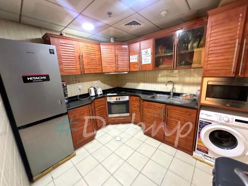 a kitchen with wooden cabinets and a washer and dryer at Pathfinder Partition Room in Barsha Heights Tecom in Dubai