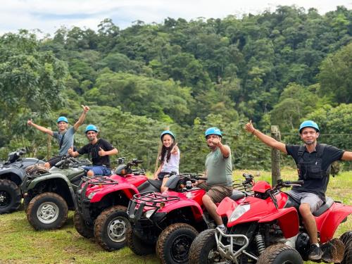 a group of people sitting on atvs in a field at Hotel Heliconias Nature Inn & Hot Springs in Fortuna