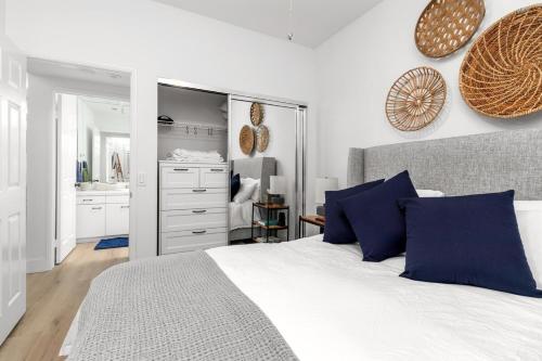 a bedroom with a bed with blue pillows and a mirror at Pacific Passion Beach House in Carlsbad